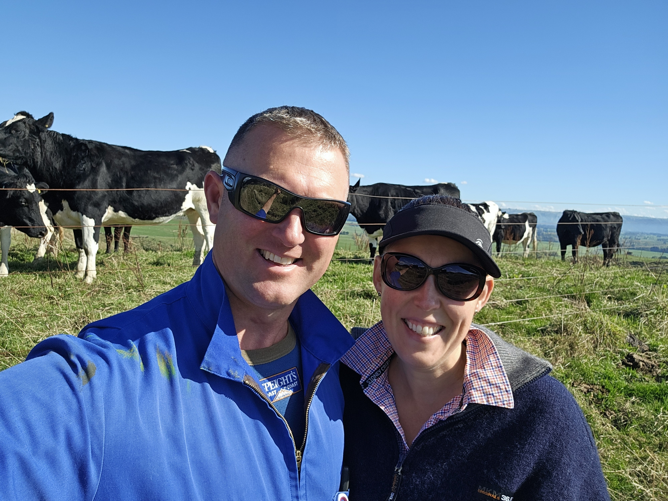 Emily Eder and Gerard Eder smiling with dairy cows in the background