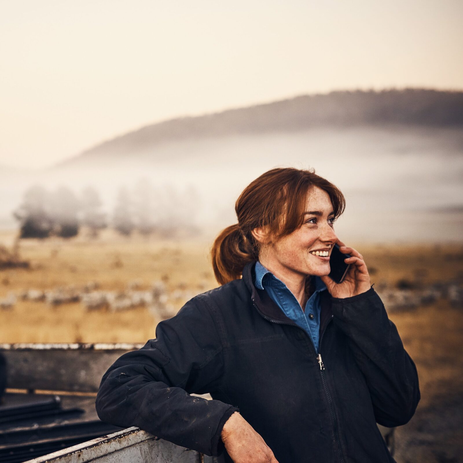 Female New Zealand farmer managing payroll from the field on her mobile